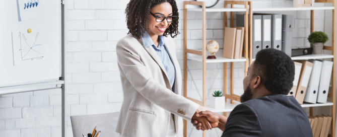 Comment utiliser LinkedIn pour trouver un job en 2021 ? Un responsable du recrutement serre la main d'un candidat à un poste vacant après un entretien de travail dans un bureau moderne, salle de photocopie